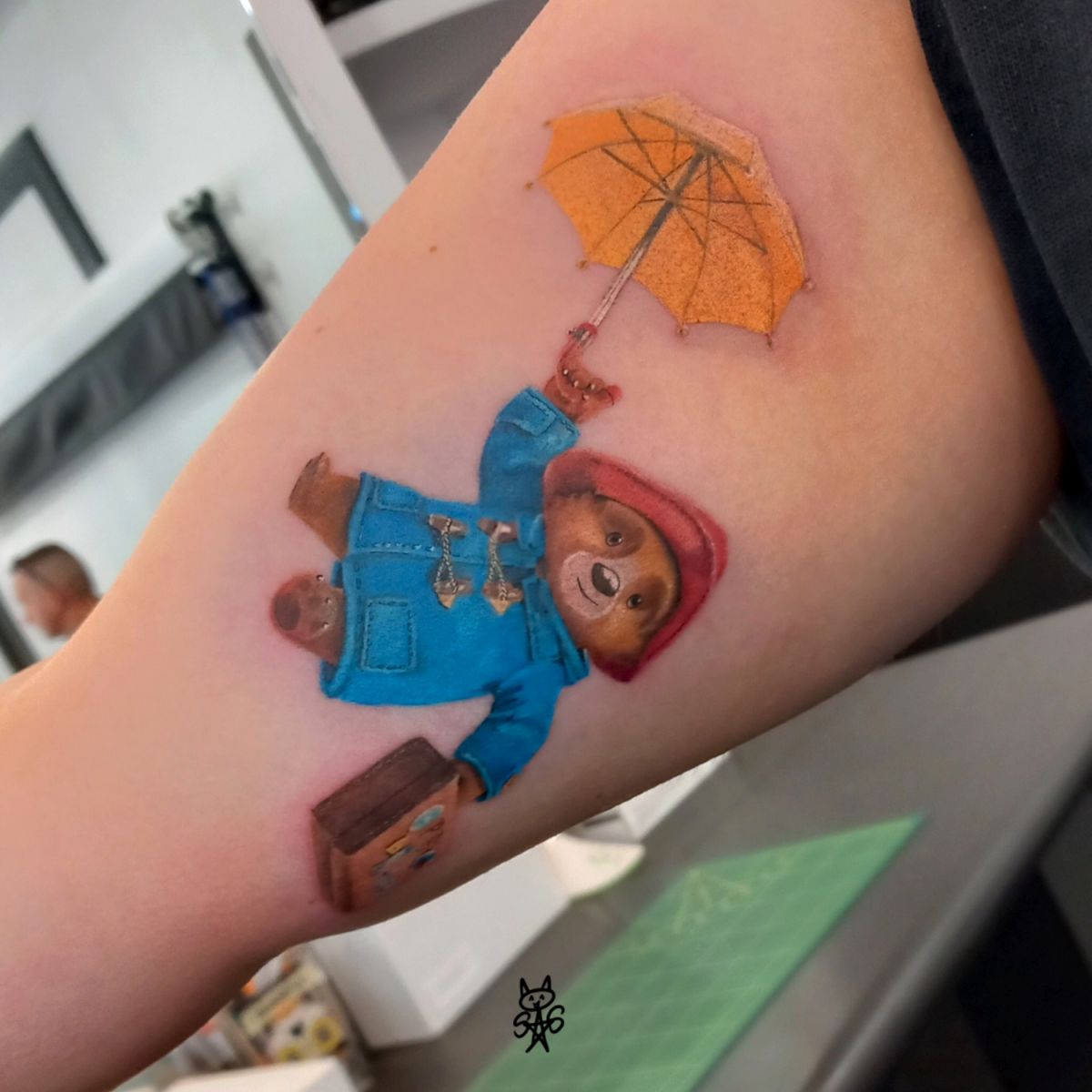 Kolorowy tatuaż przedstawiający misia Paddingtona, wykonany w ciągu jednej sesji.