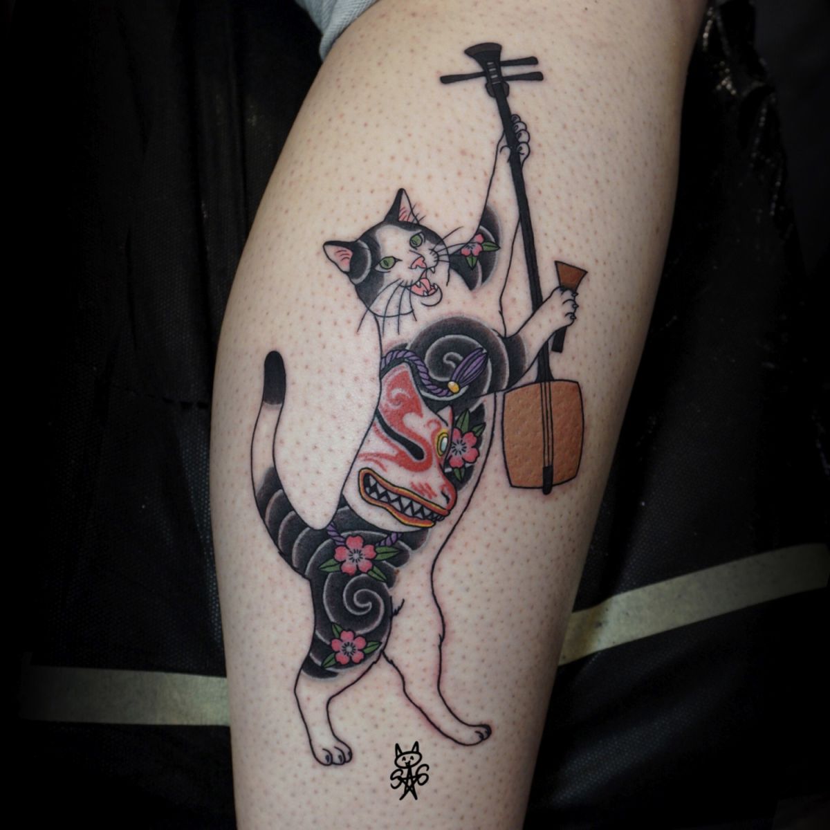 Tatuaż przedstawiający kotka z tatuażem inspirowanym japońską kulturą, grającego na japońskim instrumencie muzycznym. Wykonany w ciągu jednej sesji.
